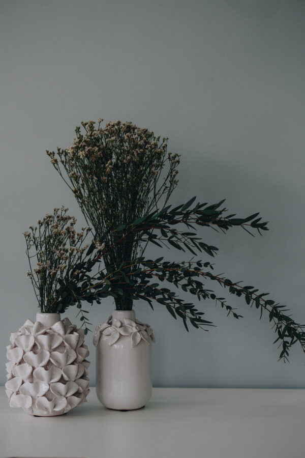 vases en céramique avec pétales de fleur en relief dessus, de couleur crème.