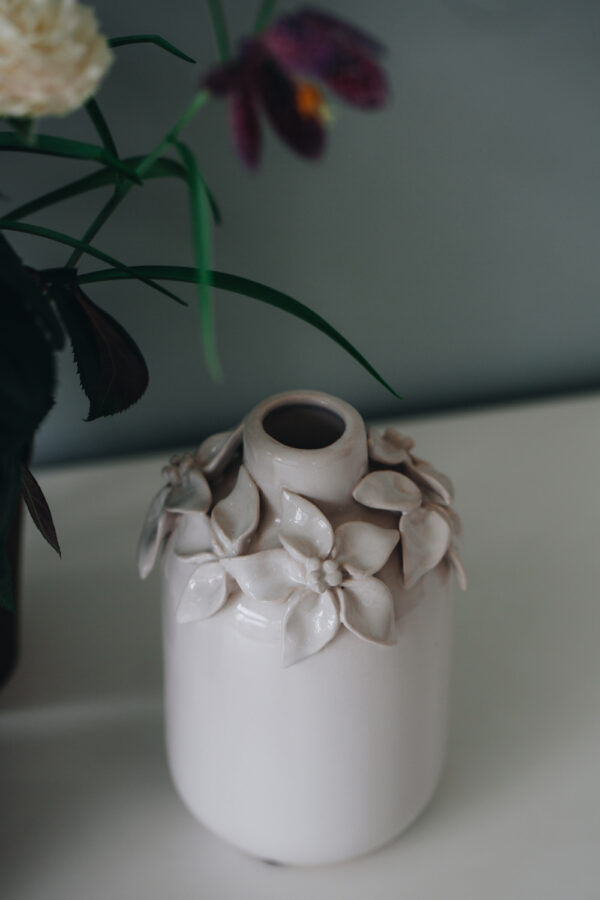 vases en céramique avec pétales de fleur en relief dessus, de couleur crème.…