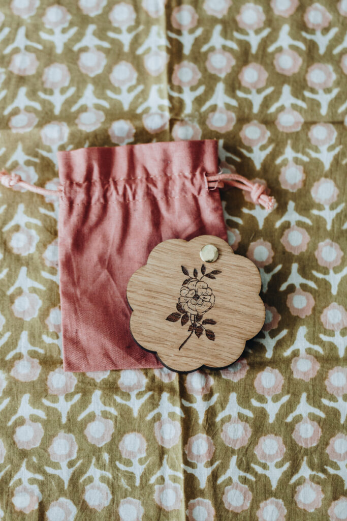 Miroir de poche coulissant en bois de chêne en forme de fleur. Gravure rose ancienne et pétales avec mots positifs. Personnalisable avec prénom. Fabrication française.